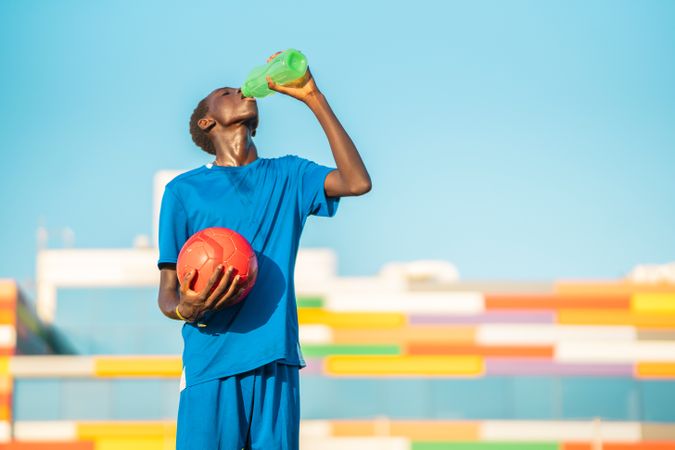 Black football player drinking water