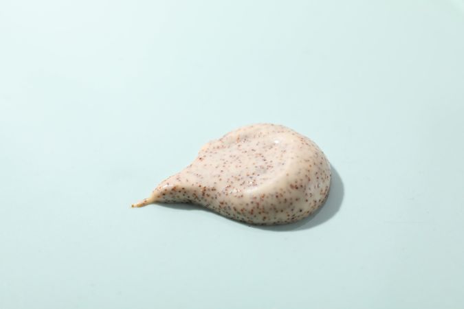 Body scrub on light blue background, close up