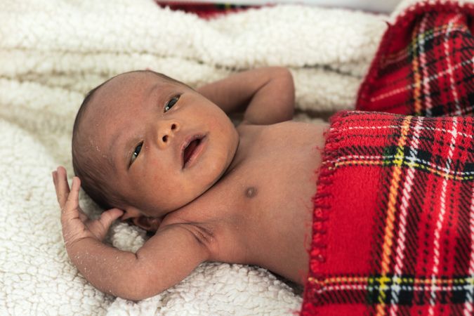 Newborn baby on soft tartan blanket