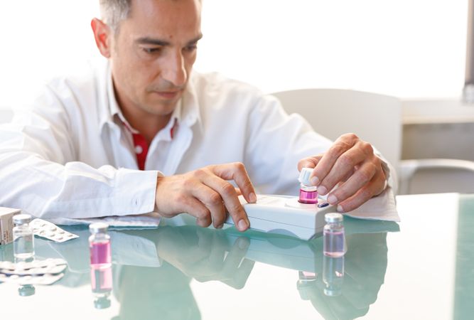 Assistant working in lab with pink liquid