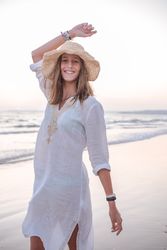 Charming woman in light white dress on wavy beach