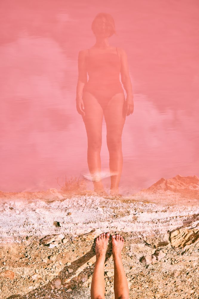 Fit woman in swimsuit posturing on pink lake shore