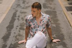 Handsome man sitting on asphalt