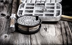 Vintage antique fly fishing reel and gear on old wood