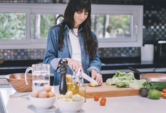 Smiling woman preparing delicious food at home