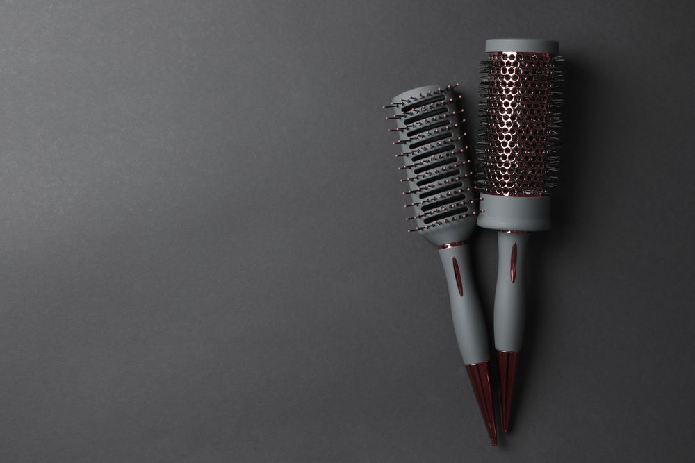 Hair brushes on dark background, space for text