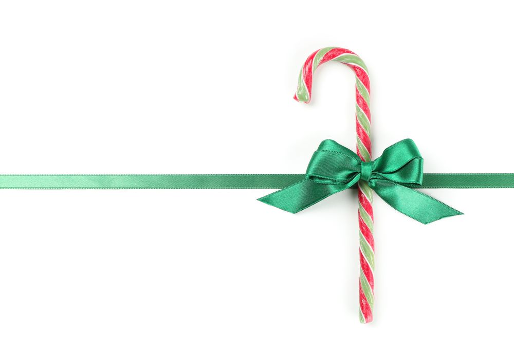 Sweet candy cane with bow isolated on blank background