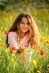 Girl relaxing amidst flowers in meadow