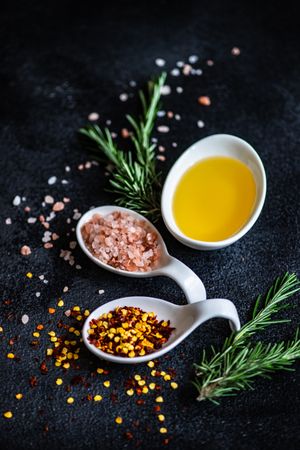 Close up of chilli flakes, oil, rosemary and salt