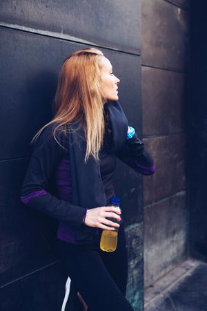Woman drinking isotonic drink while resting