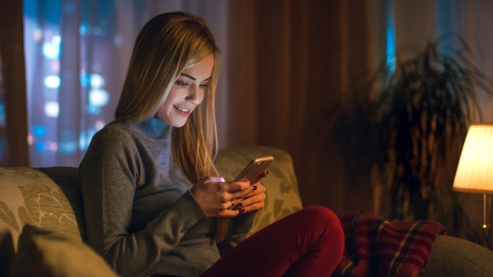 Young Woman Sitting on Her Sofa in a Living Room.