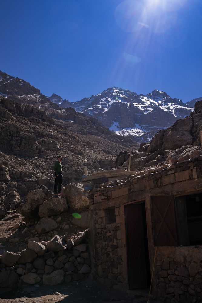 Distant man standing by rural building at mountain valley