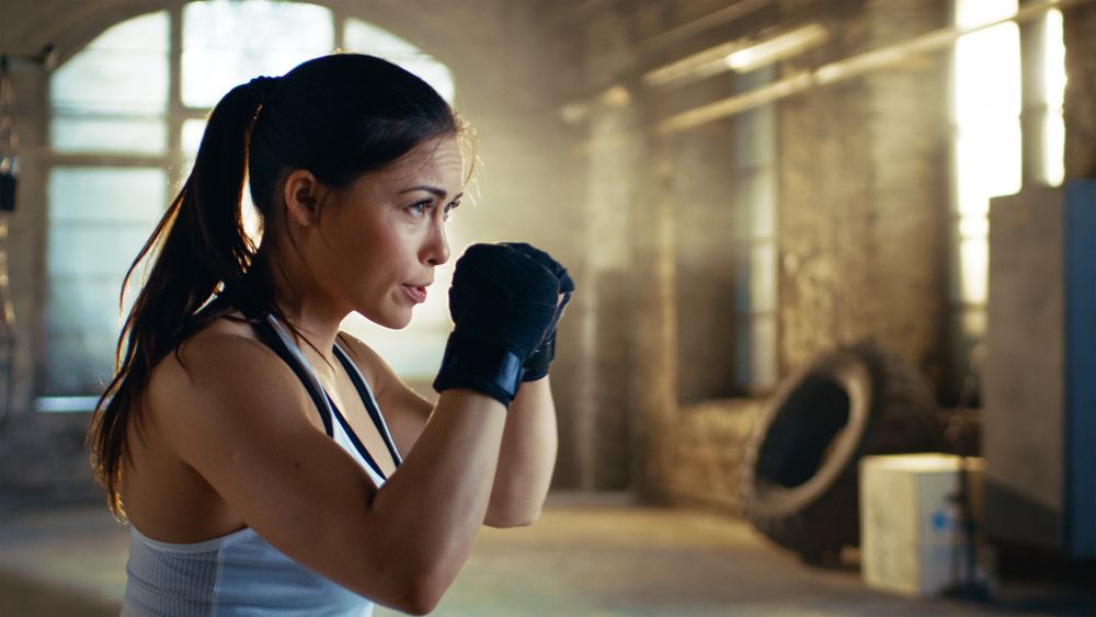 Athletic Woman holds her Arms Ready for Defending Herself.
