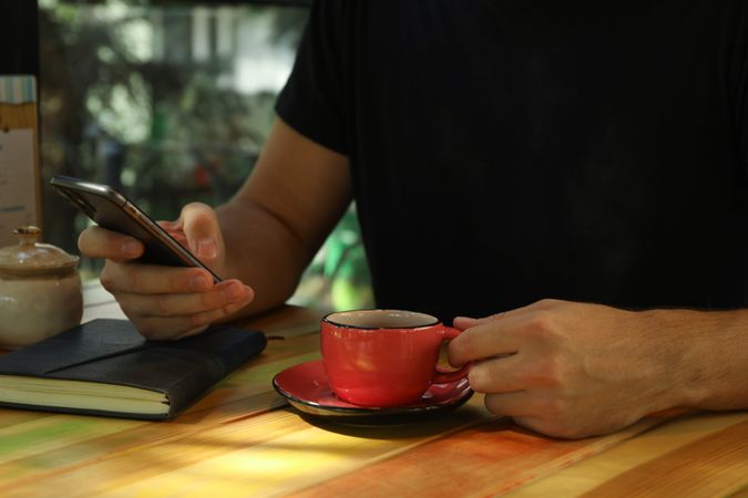 Man using phone and drink coffee in restaurant