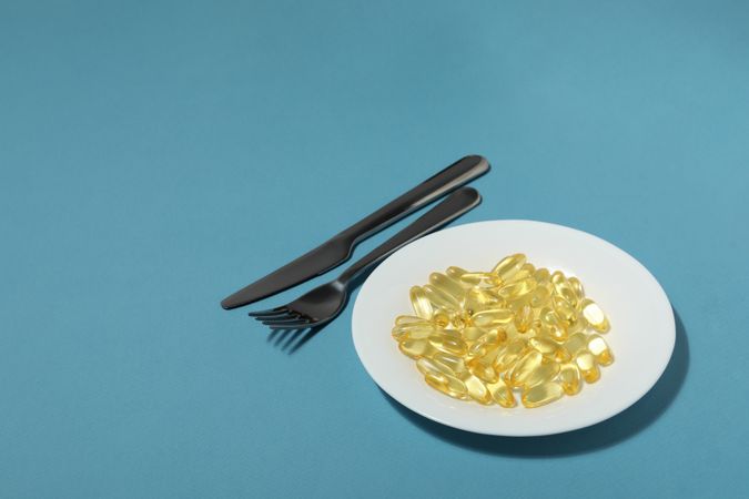 Omega pills in a bowl with a knife and fork