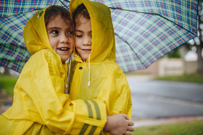 Twin sisters enjoying outdoors on rainy day