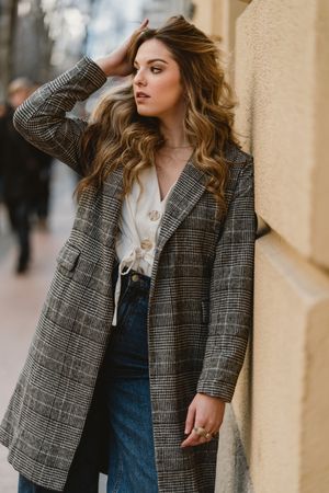Woman leaning on wall on street