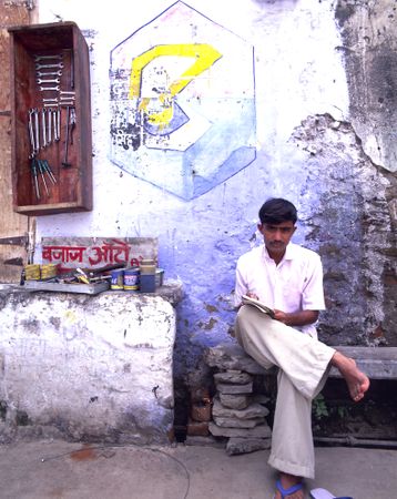 Udaipur, Rajasthan, India - Aug 2003 - Bike shop proprietor sitting outside