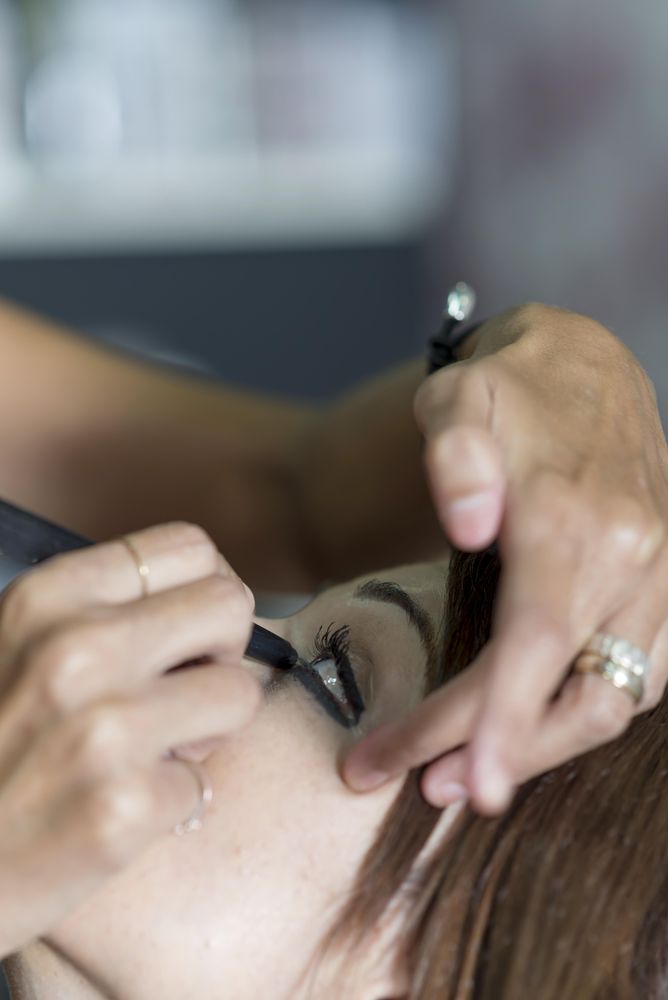 Makeup artist  putting eyeliner on model’s eyelid
