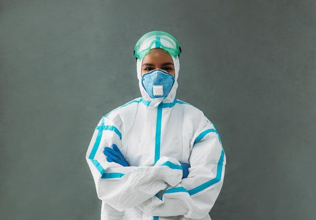 Black female medical professional in hazmat suit with her arms crossed