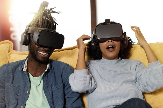 Two people on couch using VR googles