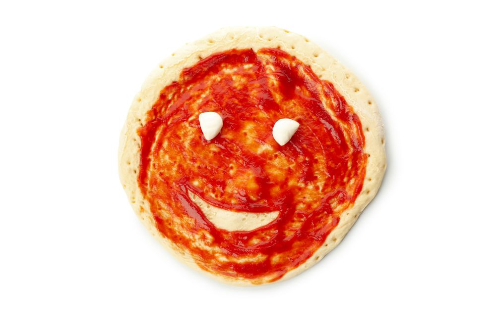Pizza dough with sauce and smile isolated on blank background