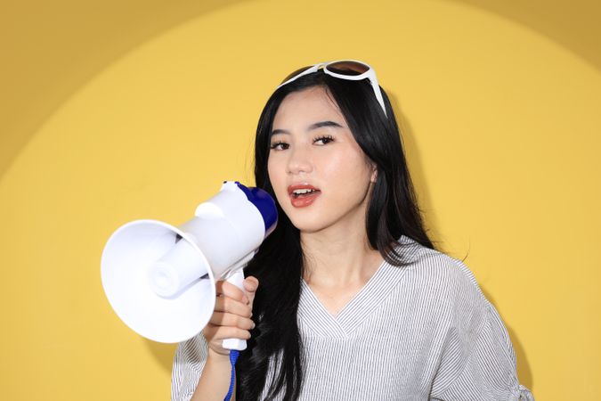 Young Woman with Megaphone, Striped White Shirt and Sunglasses