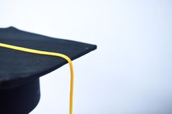 Side view of graduation cap in plain studio with space for text