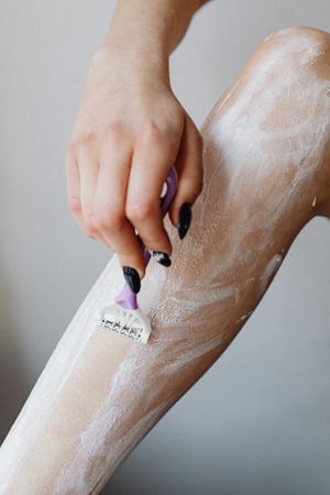 Woman shaving her leg with razor