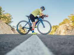 man resting while riding a bicycle on a mountain road