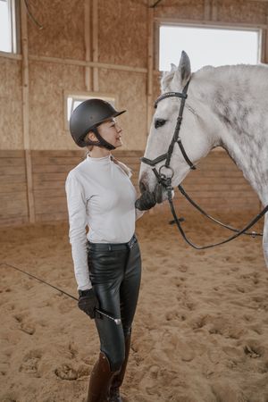 Rider with dapple gray horse in round arena