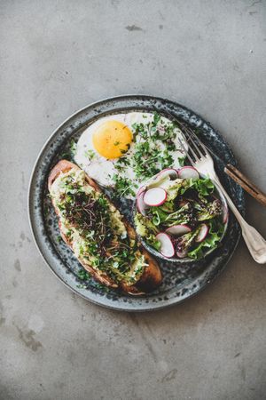 Avocado toast on sourdough bread with herbs and sprouts, copy space