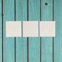Three blank photos on blue wooden background