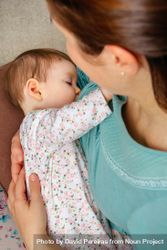 Cute baby girl breastfeeding with mother, vertical 0KdrA5