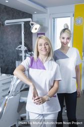 Two blonde female dentists in their bright office, vertical 4jMlX5