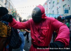 London, England, United Kingdom - August 28, 2022: Person dancing in mask and pink boiler suit bDOaQ4