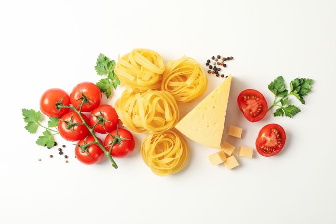 Composition with pasta and ingredients for cooking on plain background, top view