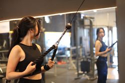 Young Woman Looking at the Mirror While Training at Gym