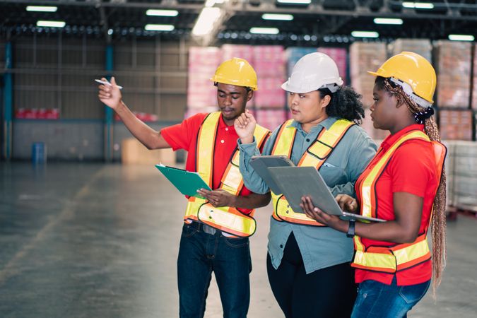 Three colleagues working together on stock in distribution center