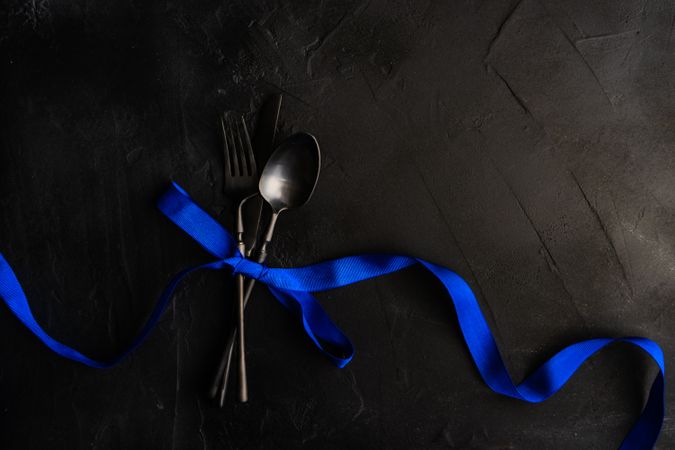Dark cutlery set wrapped in blue bow