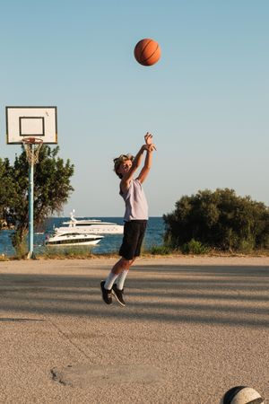 Boy playing basketball on sports ground
