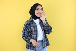 Young Asian Woman Wearing Tartan Blouse and Black Hijab Hand on Mouth Telling Secre