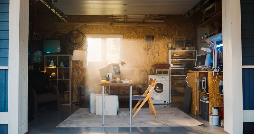 Establishing Shot Of Empty Workplace With Old Desktop Computer In Retro Garage With Random Appliances.