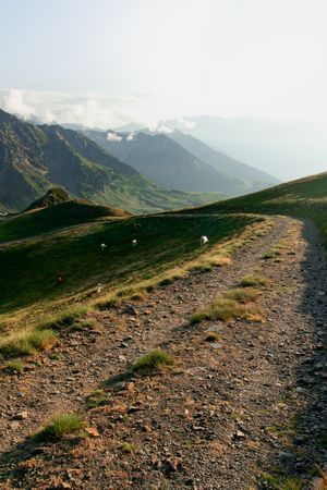 Road leading to rocky valley under clouds