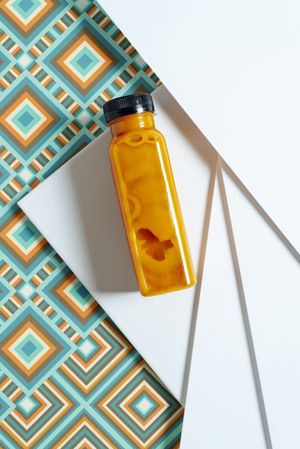 Mango and pumpkin smoothie bottle over retro textures