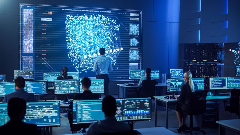 Diverse Team in a High-tech Control Room Monitors Data on Large Screens, Focusing on Cybersecurity and Seamless Operations.