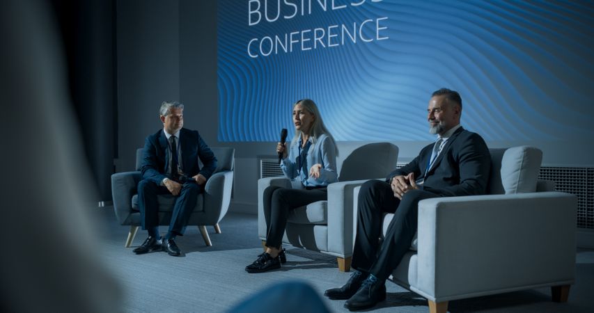 International Business Conference: Host Asking Female Tech CEO a Question In Front Of Audience Of Diverse Attendees.