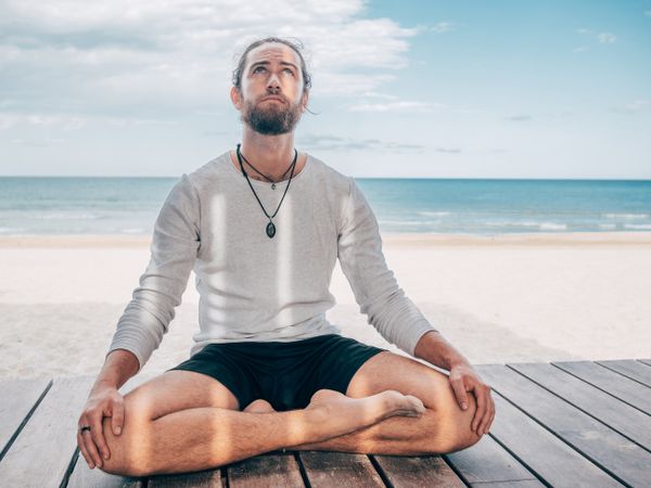 Man meditating on beach