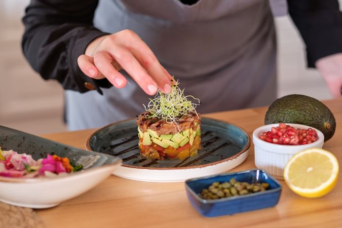 Chef garnishing tartar with microgreen