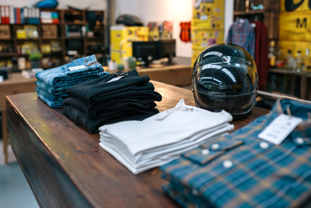 motorbike helmet and new clothes collection over counter on vintage store